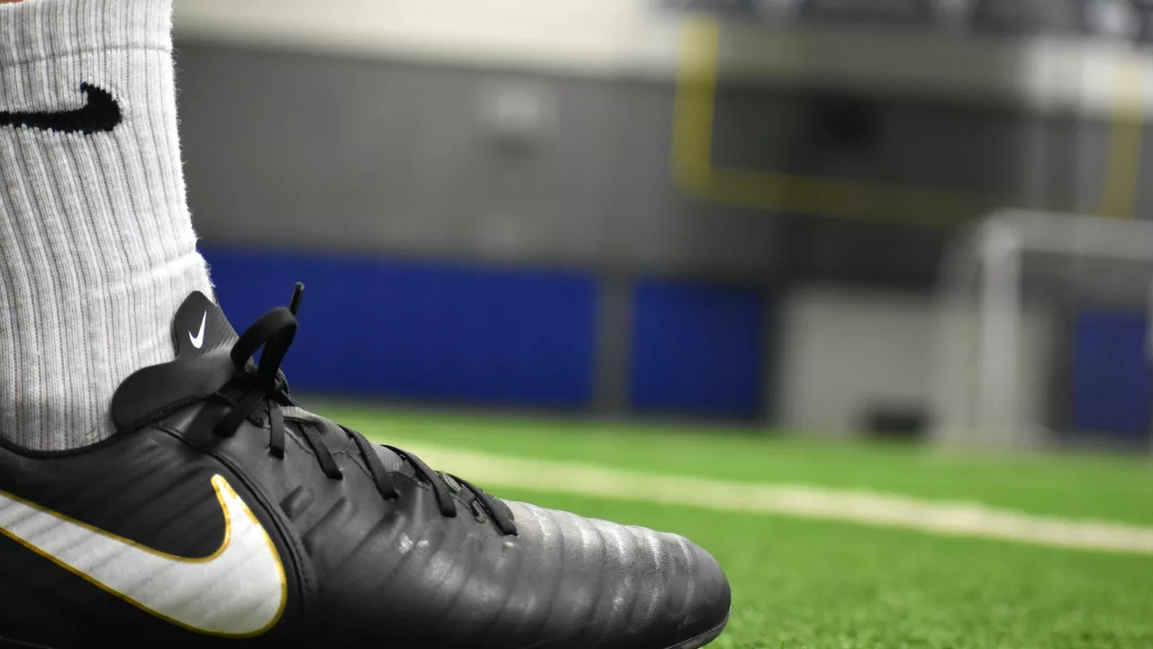 Can a football player wear soccer cleats?